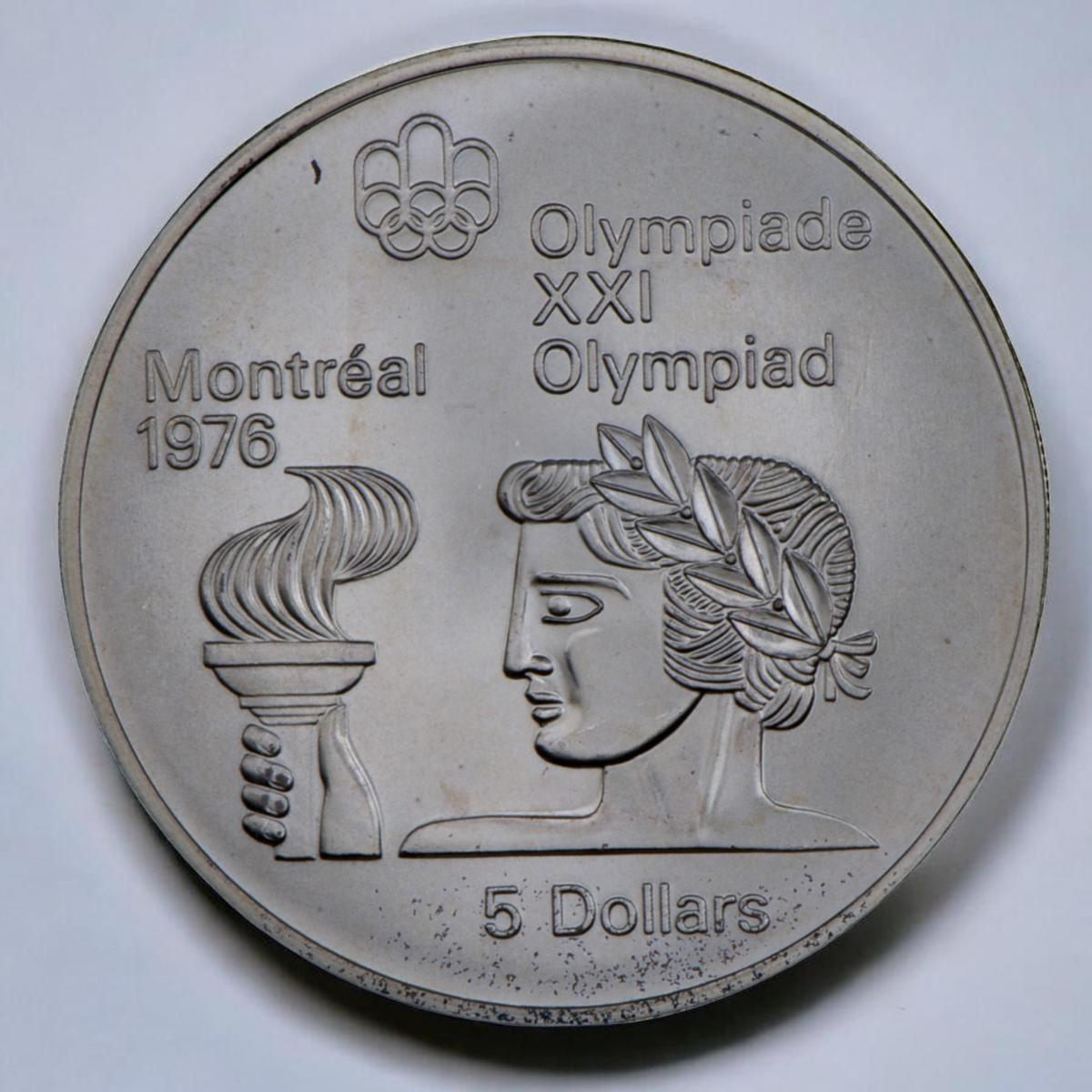 Pièce d’argent ornée d’une tête vue de profil, avec une couronne de laurier dans les cheveux, une main tient une torche devant le visage.