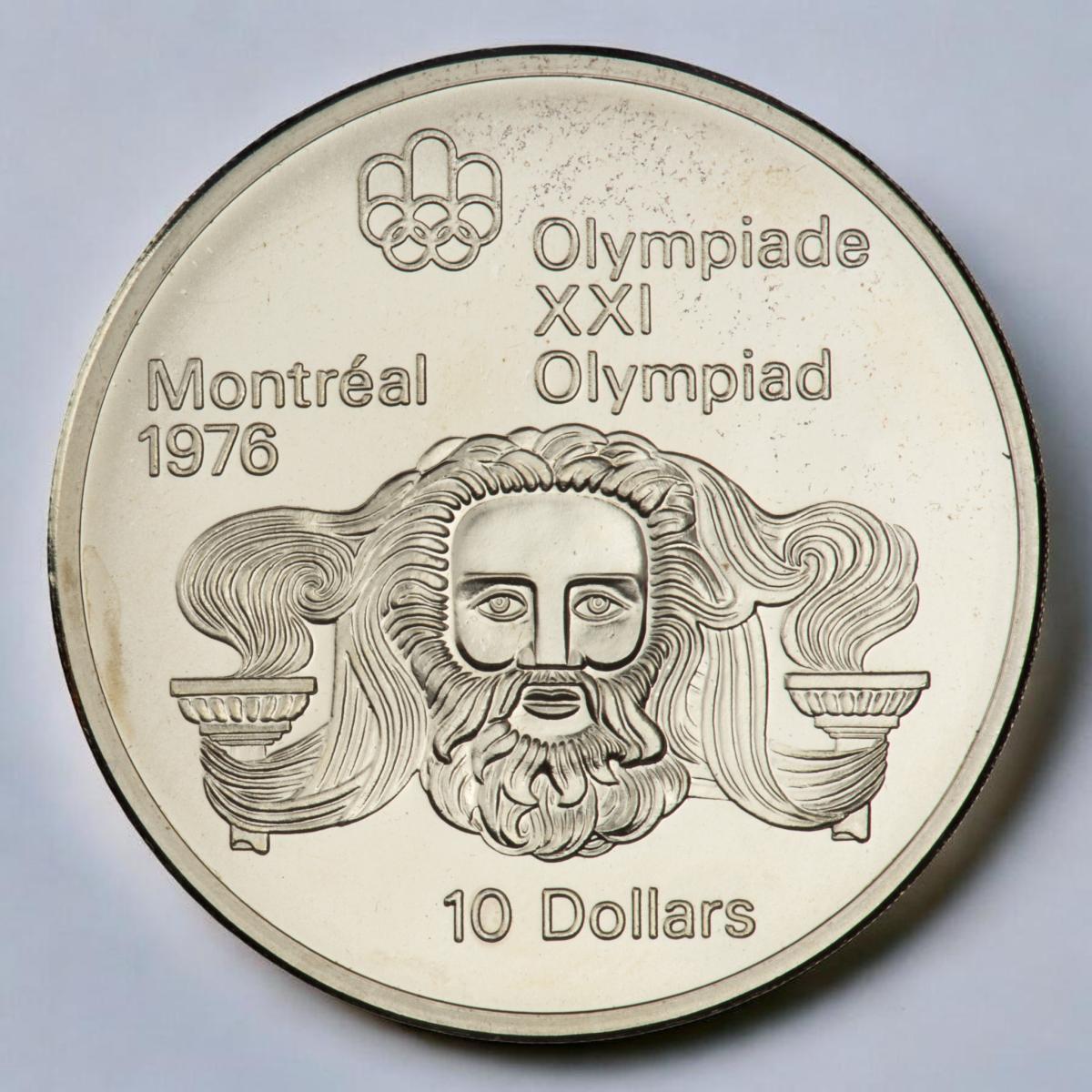 Pièce d’argent, visage d’un homme barbu avec de longs cheveux provenant des flammes des flambeaux placés de chaque côté du visage.