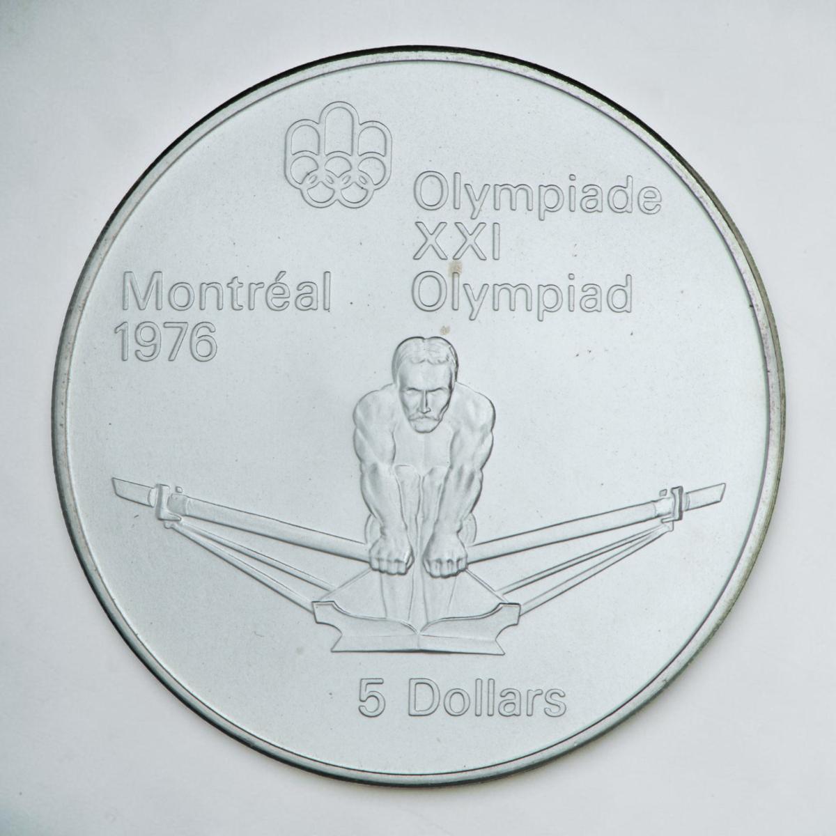 Pièce d’argent montrant de face un rameur en compétition, les rames en mouvement.