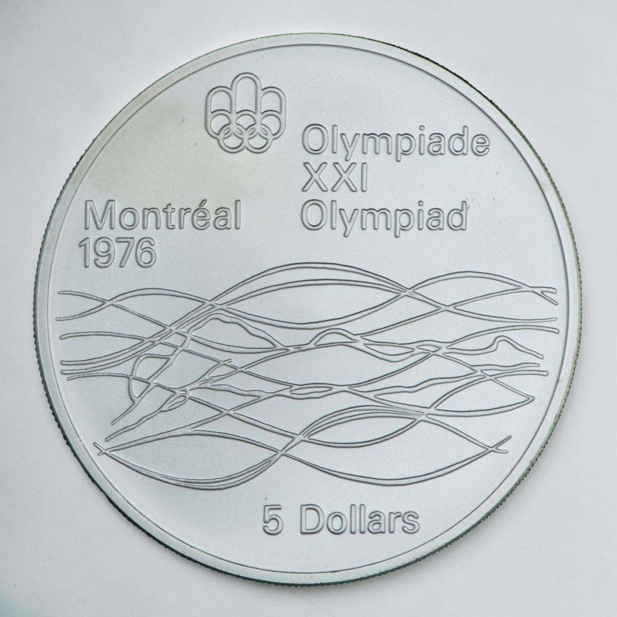 Pièce d’argent, silhouette stylisée d’un nageur, à l’horizontale, les bras au-dessus de la tête au milieu de lignes ondulées.