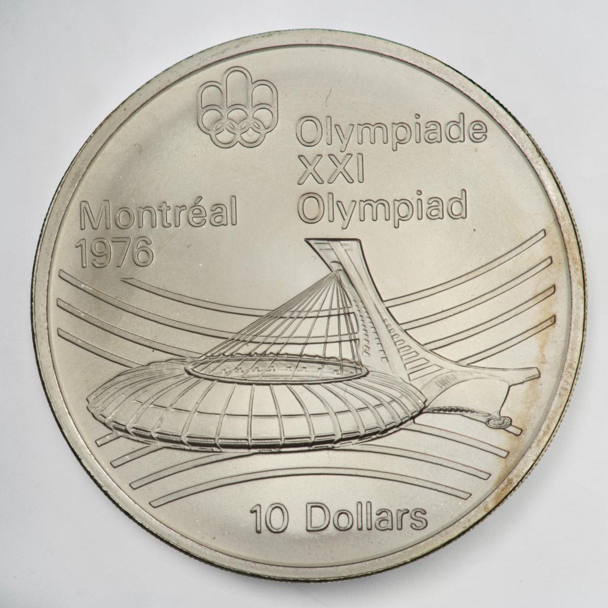 Pièce d’argent montrant, en bas, un stade ovale avec une tour à une extrémité et des lignes courbées en arrière-plan.
