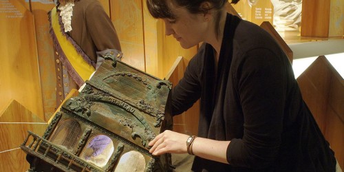 Femme prenant une pièce de monnaie dans un présentoir