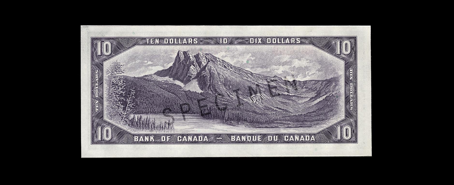 Billet de banque de dix dollars Billet de banque violet, cadre constitué de motifs géométriques, lac au pied d’une montagne boisée au sommet en forme de pyramide.