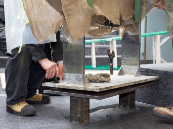 un ouvrier insère des boulons dans une plaque de métal