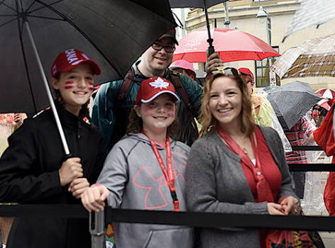 file de visiteurs sous la pluie