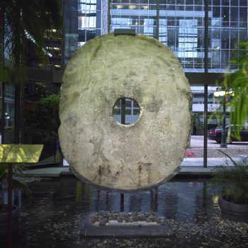 Grosse pierre ovale, grossièrement taillée, avec un trou au centre.