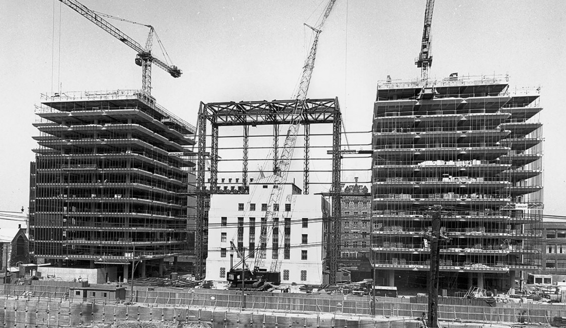 Vieil immeuble de banque en pierre, entouré de charpentes.