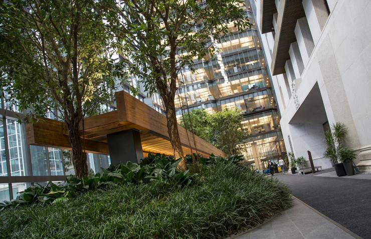 Vieil immeuble de pierre grise à l’intérieur d’un atrium verdoyant.