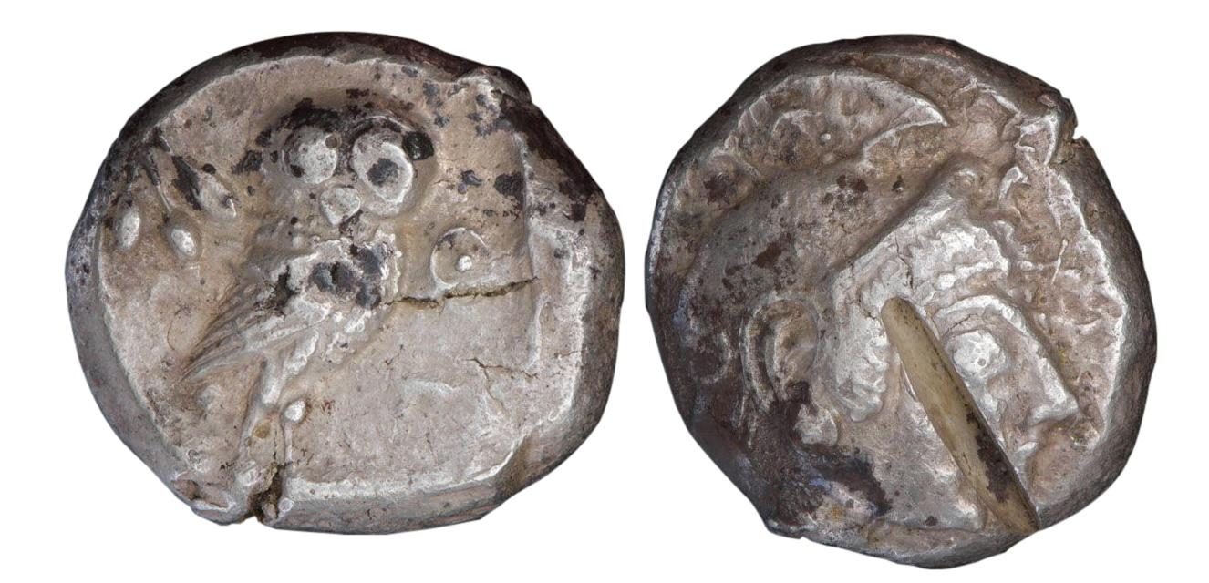 Les deux faces d’une pièce de monnaie : au recto, on distingue un hibou; au verso, une profonde entaille faite dans le métal.