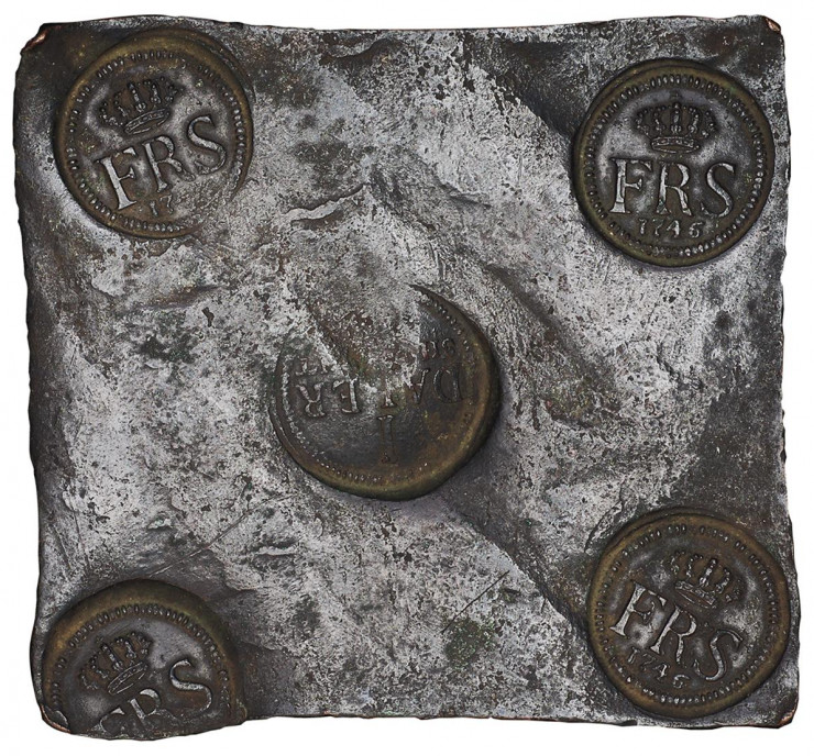 Plaque de métal carrée avec cinq symboles officiels ronds estampillés dessus. 