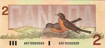 Billet de banque rose sur lequel figurent deux oiseaux à la poitrine rouge et au dos gris dans une prairie.