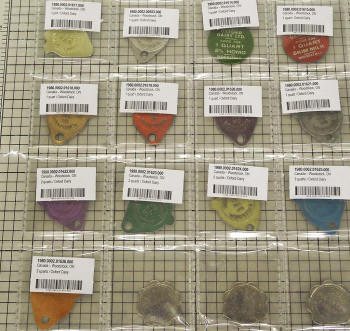 Feuille de plastique transparent avec des pochettes, chacune contenant un jeton de couleur.