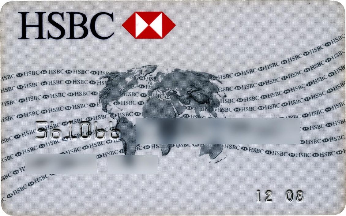 Carte bancaire grise avec un logo rouge et blanc en haut, une carte du monde au centre et des lignes courbes en trame de fond. 