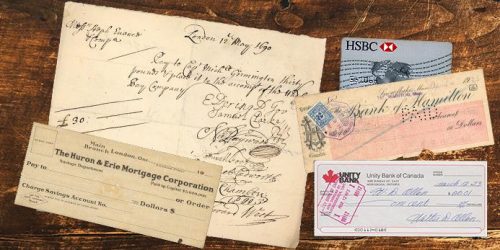 Photo, a tabletop with several printed paper forms and hand-written documents plus a bank card.
