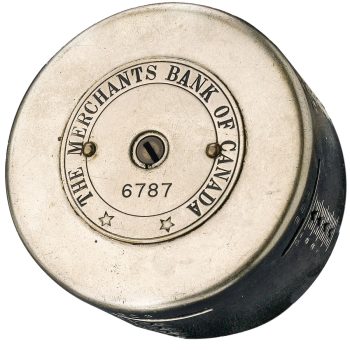 Cylindre d’acier gravé du nom d’une banque avec une fente et un numéro de série sur le dessus. 