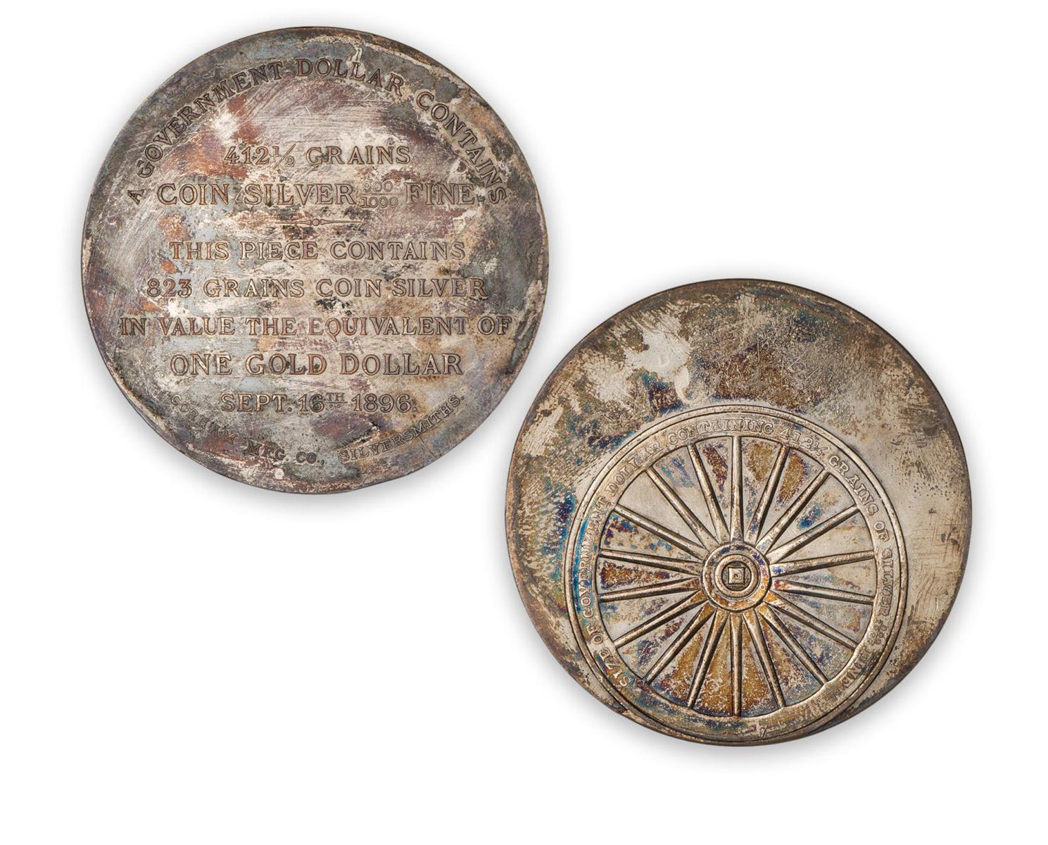 Jeton rond en argent terni, avec une longue description d’un côté, et une roue de l’autre.