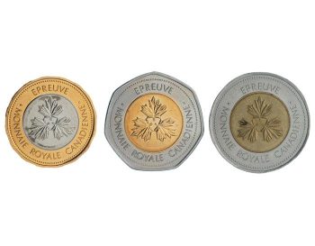 Trois pièces de monnaie : une au centre argenté et au tour doré; une au centre doré et au tour argenté, dont le pourtour présente sept facettes; et une au centre en bronze et au tour argenté – toutes ornées de trois feuilles d’érable au milieu et d’une inscription autour sur les deux côtés.