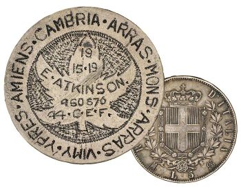 Pièce polie, feuille d’érable, mots et dessins gravés à partir de petits points; au verso, un bouclier orné d’une croix. 