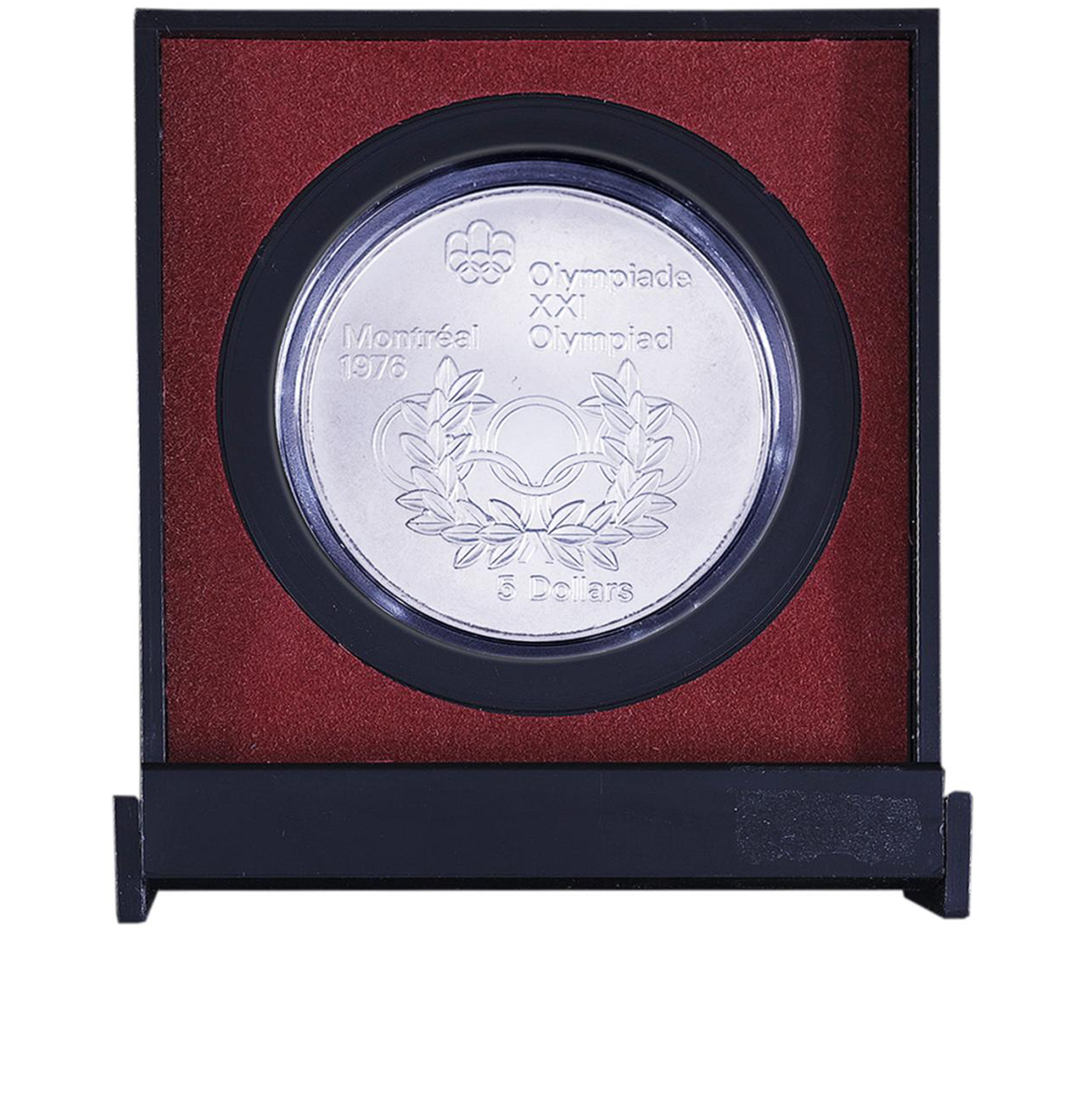 Boîtier en plastique rouge et noir contenant une pièce d’argent ornée d’anneaux entrelacés et d’une couronne.