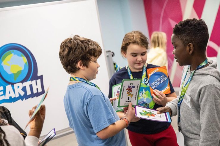 Des enfants jouent à un jeu Un adulte et un enfant tiennent des cartes de jeu colorées.