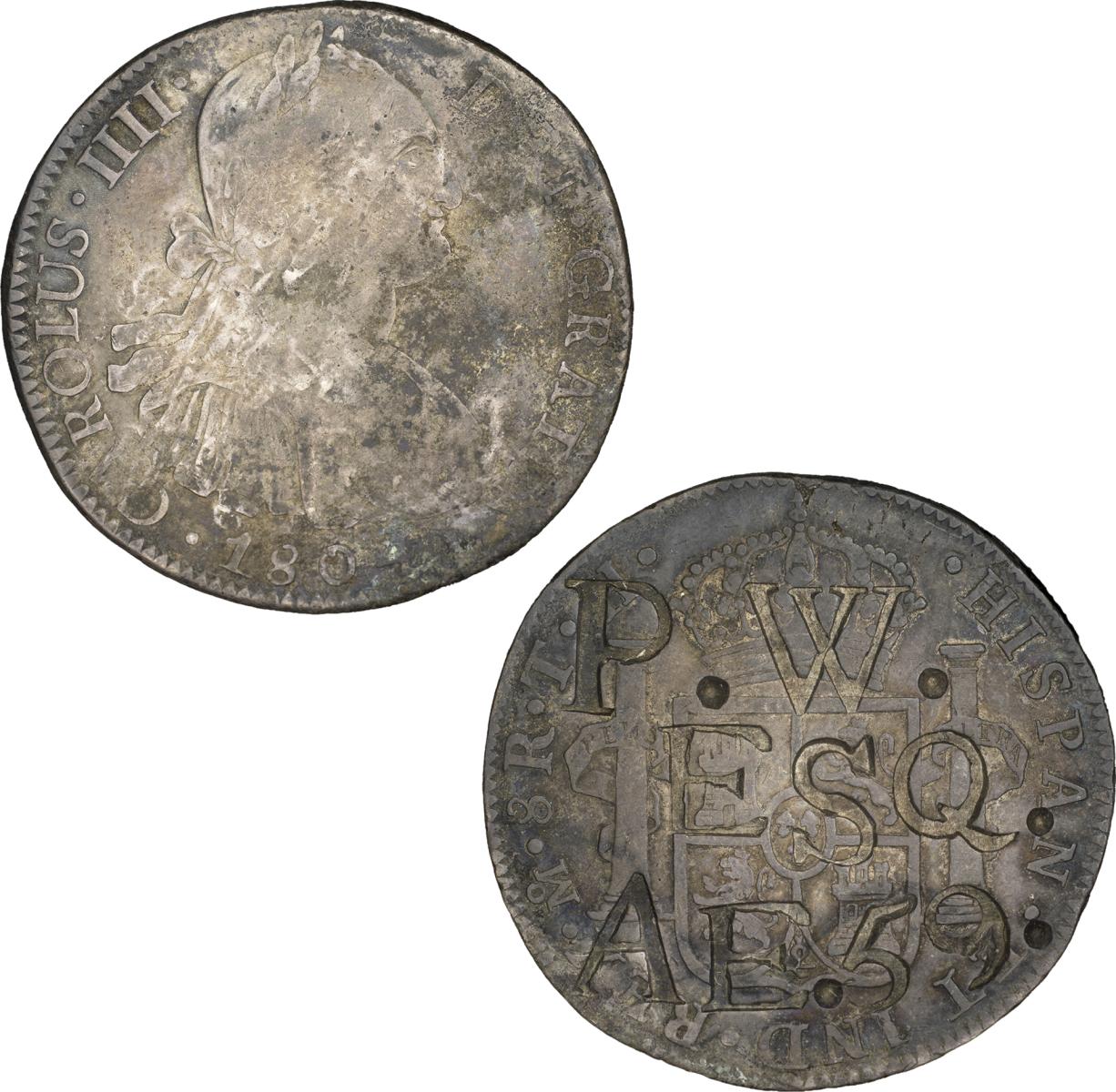Pièce hispano-américaine contremarquée Revers d’une pièce grise portant des lettres et des chiffres poinçonnés sur la surface. Avers d’une pièce grise montrant la tête d’un homme tournée vers la droite, avec une inscription sur le pourtour.